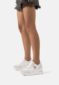 Sneakers bianchi realizzati in materiali sintetici con dettagli in suede. Presentano un design a profilo basso, una suola ammortizzata e chiusura con lacci.