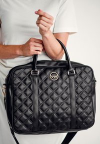 Schwarze gesteppte Lederhandtasche mit doppelten Griffen, einem Reißverschluss und einem goldenen Logo-Akzent. Verfügt über einen abnehmbaren Schulterriemen.