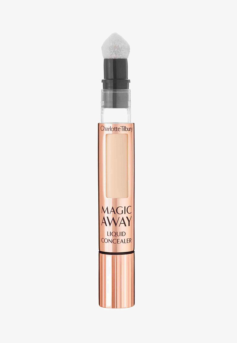 Correcteur liquide dans un tube transparent avec une base en or rose, présentant un embout applicateur doux et rond ainsi qu'une fenêtre de produit visible.