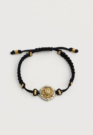 Schwarzes geflochtenes verstellbares Armband mit gold- und silberfarbenem Löwenkopfmotiv in der Mitte und goldfarbenen dekorativen Perlen.