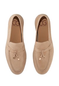 Mocassins en suede beige clair avec des lacets en cuir et des accents en métal doré. Texture lisse et forme arrondie avec des coutures contrastantes.