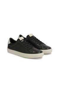 Adidași din piele neagră, cu un design elegant, având o talpă din cauciuc alb contrastantă și accente minimaliste. Include sistem de închidere cu șireturi și guler căptușit.