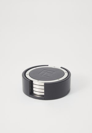 Suporte debaixo de copo de couro preto com um topo circular em metal prateado, apresentando um logotipo em relevo. Contém vários suportes debaixo de copo empilhados dentro.