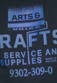 Blauwe grafische tekst op een donkere stof met de tekst "ARTS & CRAFTS SERVICE EN BENODIGDHEDEN" met extra details en contactnummer hieronder.