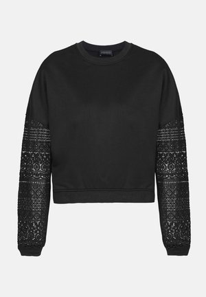 Fekete cropped pulóver, egyszínű testtel és texturált csipke ujjal. Bordázott mandzsettákkal és tónusos nyakkivágással rendelkezik, hangsúlyozva az ujjakon lévő csipke részleteket.