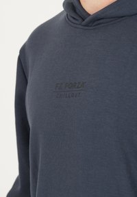 Marinblå hoodie i mjukt bomullsmaterial med en avslappnad passform; har en tryckt logotyp "FZ FORZA CHILLOUT" på framsidan.