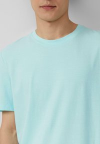 Lichtblauw katoenen T-shirt met een ronde hals en korte mouwen, met een gladde textuur en een schoon, eenvoudig ontwerp.