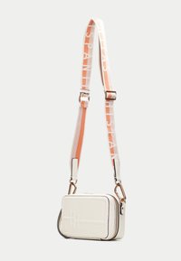 Bílá obdélníková crossbody taška s embosovaným vzorem, se zipovým uzávěrem a vzorovaným nastavitelným popruhem v oranžové a bílé barvě.