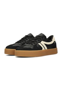 Paar schwarzer Low-Top-Sneaker mit weißen Seitenstreifen und dicken braunen Gummisohlen, geschnürt und nach links geneigt auf weißem Hintergrund.