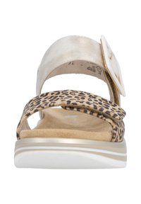 Leopard-print sandal with a gold metallic strap and a large white buckle. Soft beige footbed on a white sole, featuring cutouts on straps.