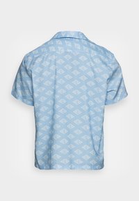 Lichtblauwe shirt met korte mouwen en een wit geometrisch ruitpatroon, van achteren weergegeven op een effen achtergrond.