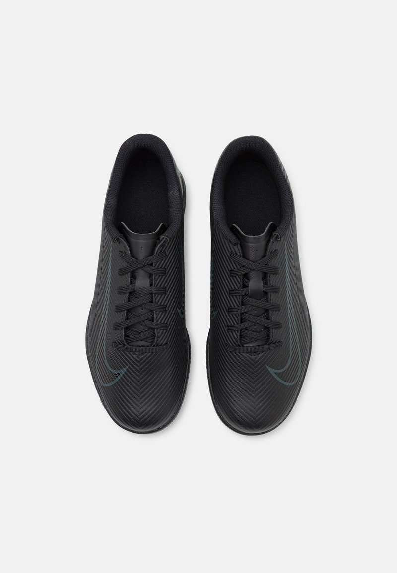 Zwarte sportieve schoenen met een getextureerde bovenkant, voorzien van dunne veters, een ronde neus en een subtiele logo-accent in donkerblauw.
