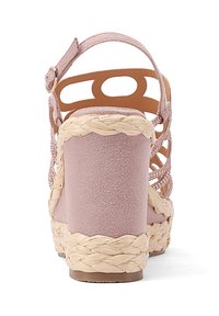 Sandalo con zeppa in suede rosa, dettagli in paglia intrecciata e apertura sul retro. Presenta ritagli decorativi e una cinghia alla caviglia per una vestibilità sicura.