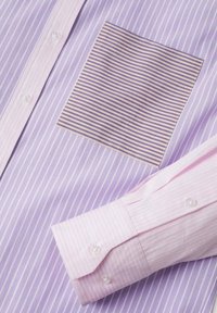 Lavendelfarbenes Hemd mit vertikalen Streifen und einer gestreiften Tasche in Lavendel und Pink. Einfarbiger pinkfarbener Ärmel mit Knopfverschluss.