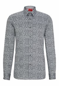 Camisa de manga larga en gris con un patrón de cachemira negro, con cuello con solapas y cierre frontal con botones. El material parece suave.