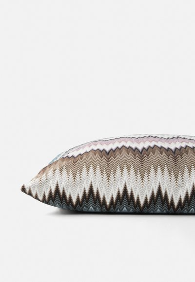 Decorative pillow with chevron zigzag pattern in brown, white, and pink tones on a white background.