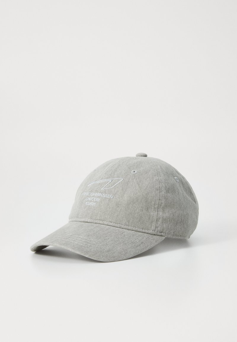 Casquette grise en tissu avec une visière courbée, comportant un texte brodé en blanc. Le design comprend des trous de ventilation et une sangle ajustable.