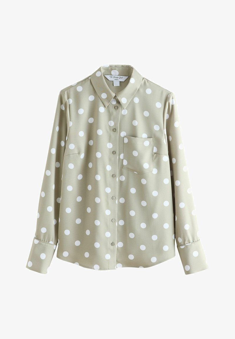 Chemise beige à manches longues avec boutons, à pois blancs et poche poitrine, présentée sur fond blanc.