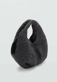 Sac à main noir en tricot avec une forme décontractée et asymétrique, doté de deux grandes poignées surdimensionnées. Fabriqué en fil texturé avec un tissage ouvert.