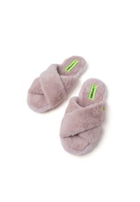 Zapatillas esponjosas de tiras cruzadas en rosa claro, con suave material de piel sintética y una suela texturizada, con una etiqueta verde en la plantilla.