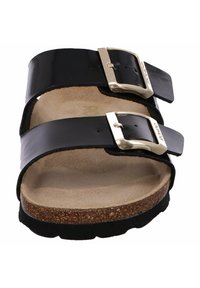 Sandales en cuir verni noir avec deux larges brides et boucles dorées. Semelle intérieure en liège et semelle en caoutchouc noir texturé pour une traction.