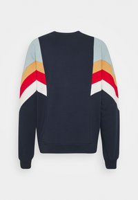 Felpa blu marina con strisce a zigzag multicolori in blu, oro, rosso e bianco sulle spalle; polsini e orlo a coste; morbido materiale in cotone.