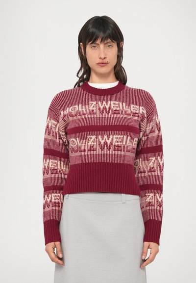 Pull en tricot bordeaux avec des rayures crème présentant des motifs de texte répétés. Poignets et ourlet côtelés, coupe décontractée, matière texturée.