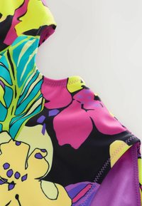 Farverigt svømmetøj med et blomstermønster i gule, pink, lilla og grønne farver. Fremstillet af strækbart materiale med matchende syninger.