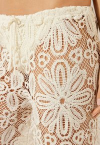 Shorts de encaje con cobertura, hechos de material blanco de ganchillo, con patrones florales, cintura elástica con cordón y diseño de tejido abierto.