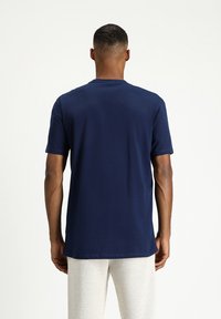 T-shirt a maniche corte di colore blu navy realizzato in cotone, con collo a giro e vestibilità standard, design semplice senza motivi o dettagli visibili.