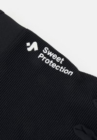 Μαύρη συμπιεστική κάλτσα φτιαγμένη από ελαστικό ύφασμα; διαθέτει ραβδωτή υφή και λογότυπο "Sweet Protection" σε λευκό. Στρογγυλεμένες άκρες στις άκρες.