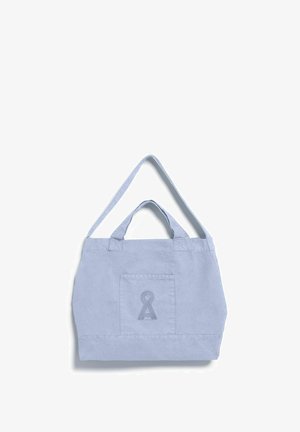 Hellblaue Segeltasche mit Fronttasche und einem aufgedruckten dunkelblauen schlüssellochförmigen Symbol, mit kurzen Griffen und einem längeren Schulterriemen.