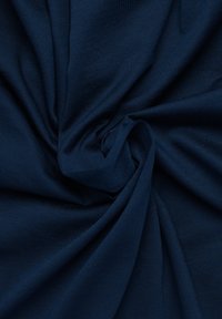 Tessuto blu navy con una superficie liscia, pesantemente drappeggiato e torcigliato, che mostra un design semplice senza motivi o accenti.