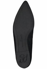 Zapato plano de ante negro con diseño de punta afilada y suela de goma texturizada. Presenta un logo grabado en el talón.