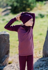 Children's maroon activewear, featuring long sleeves, a relaxed fit, and matching beanie. Material appears soft and stretchy, suitable for movement.
