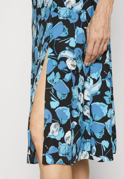 Φόρεμα με λουλουδάτο σχέδιο σε μαύρο χρώμα, παρουσιάζοντας μπλε και λευκά λουλούδια, με λεπτομέρεια πλάγιου σκισίματος και μαλακή, ελαφριά υφή υφάσματος.