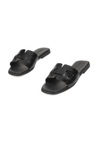 Sandalias de slide negras con un acabado texturizado, que presentan correas anchas, un diseño de punta abierta y una suela plana. "ZALANDO" grabado en la plantilla.