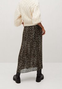 Maxi sukně s leopardím potiskem, vyrobená z lehkého materiálu. V kombinaci s bílým svetrm s pleteninou a černými kotníkovými botami.