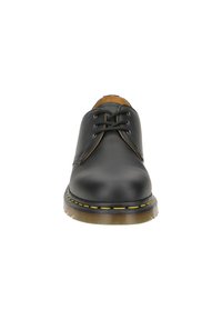 Scarpa nera in pelle con lacci, punta arrotondata, cuciture gialle lungo la suola e una suola esterna in gomma spessa e texturizzata.