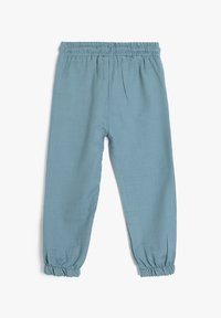 Hellblaue Leinenhosen mit elastischem Bund, schmal zulaufenden Beinen und gerafften Säumen. Mit vorderen Falten für zusätzlichen Detailreichtum.