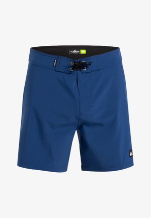 Blå simshorts i syntetmaterial. Har snörning framtill, elastisk midja och logotyp på nedre vänstra sidan.