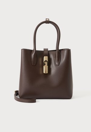 Borsa a mano in pelle marrone scuro con due manici, una tracolla removibile e una fibbia centrale color oro su sfondo semplice.