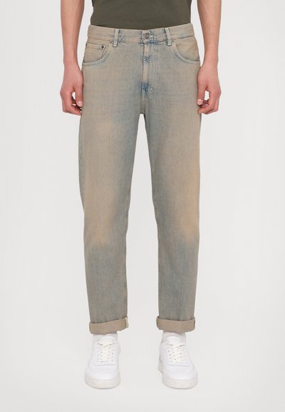 Light blue denim jeans with a relaxed fit, featuring a mid-rise waist, five-pocket design, and rolled cuffs. Paired with white sneakers.