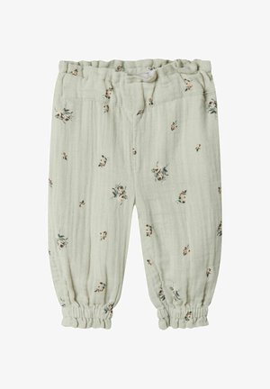 Helle grüne Kinderhose aus weichem Stoff mit einem floralen Muster in Pink und Grün. Elastischer Bund und geraffte Bündchen an den Knöcheln.