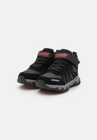 Scarpe da trekking impermeabili nere con accenti grigi, parte superiore in rete e suola in gomma. Presentano una cintura regolabile e lati testurizzati per una maggiore trazione.