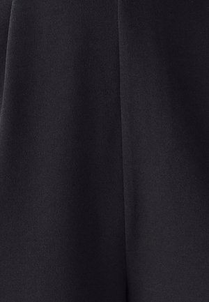 Černá tkanina s hladkým povrchem, která má splývavý design a vertikální šev probíhající uprostřed.