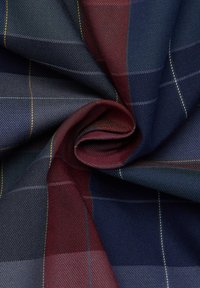Tissu plié avec un motif écossais de bleu marine, bordeaux, gris, et de fines lignes jaunes et blanches dans une texture de tissage sergé.