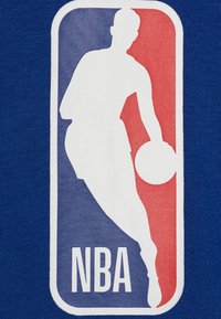Silhouette di un giocatore di basket che dribbla, all'interno di un rettangolo verticale rosso e blu con il testo "NBA" sotto su uno sfondo di tessuto blu.
