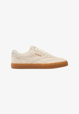 Sneaker bianca Reebok a taglio basso con dettagli beige e suola in gomma naturale, con lacci e logo sul lato e sulla linguetta.
