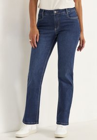 Mörkblå denimjeans med rak bendesign, som har subtil kontrasterande sömmar och en enkel knappstängning i midjan.